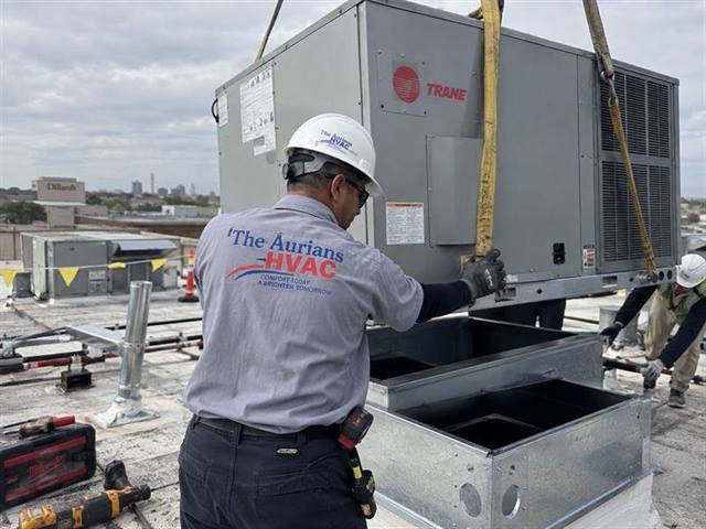 Crane lifting a rooftop unit into place