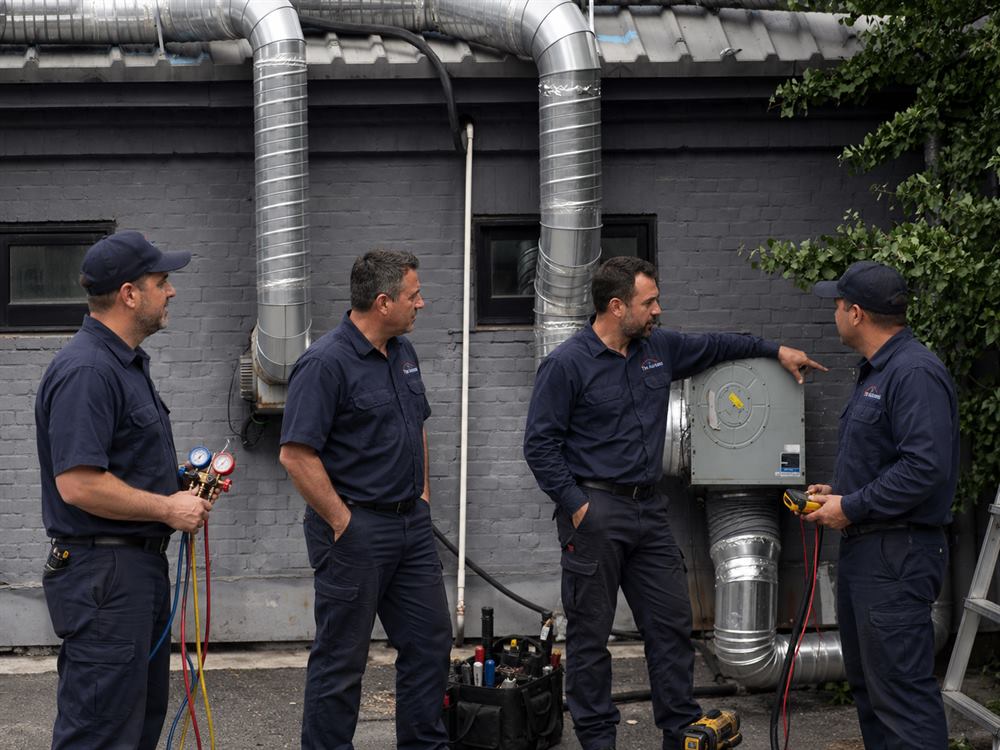 Professional HVAC technician performing seasonal heating and cooling maintenance on a residential air conditioning unit